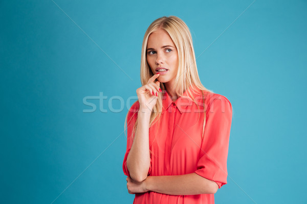 Portrait of a confused girl in red dress looking away Stock photo © deandrobot