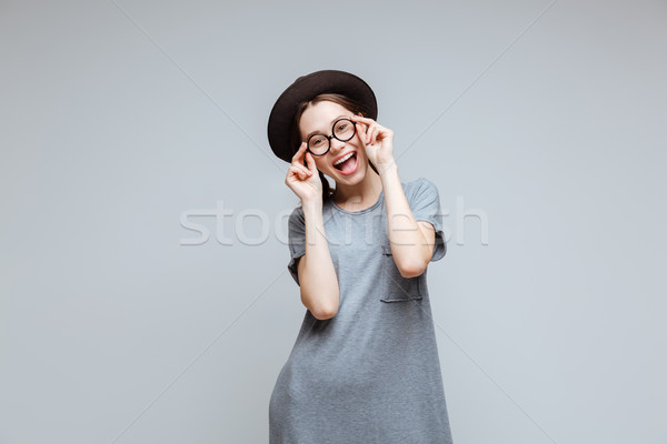 Happy Female nerd in black hat Stock photo © deandrobot