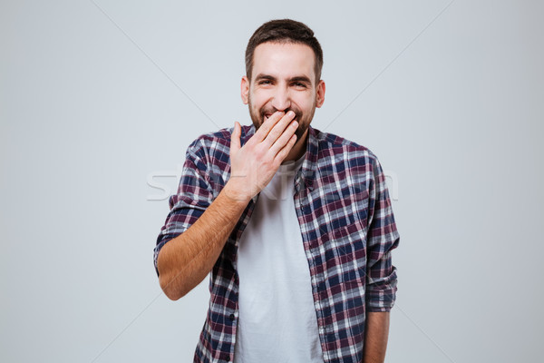 Laughing Bearded man in shirt covering mouth Stock photo © deandrobot