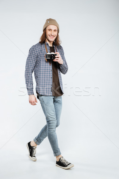 Vertical image of Hipster holding retro camera Stock photo © deandrobot