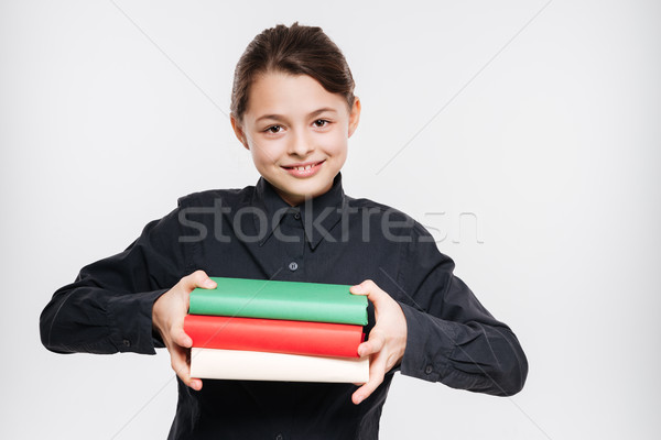 Cheerful young girl holding books Stock photo © deandrobot