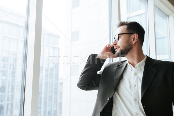 Barbudo homem de negócios falante telefone terno Foto stock © deandrobot