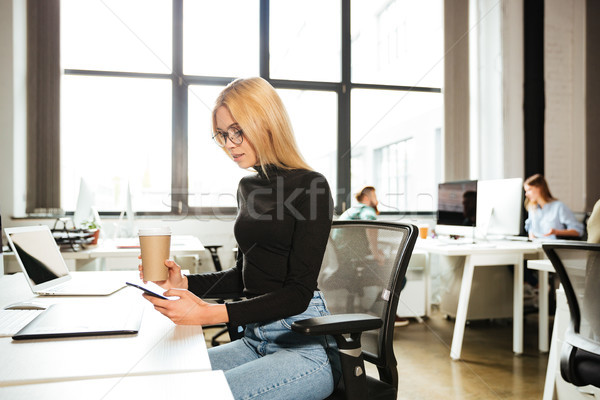 Stock photo: Woman work in office using mobile phone drinking coffee