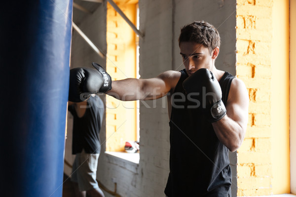 Strong boxer training in a gym. Stock photo © deandrobot