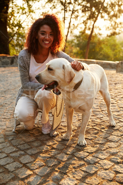 Portrait of african lady walking with dog in park Stock photo © deandrobot