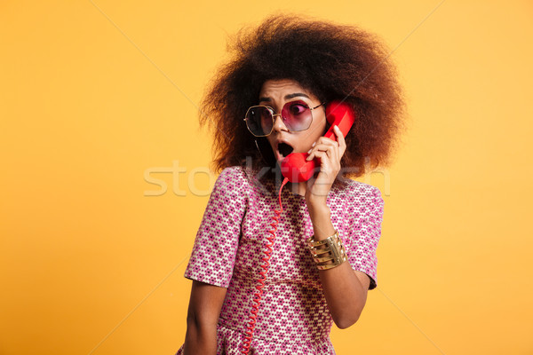 Close-up photo of amazed retro girl with afro hairstyle holding  Stock photo © deandrobot