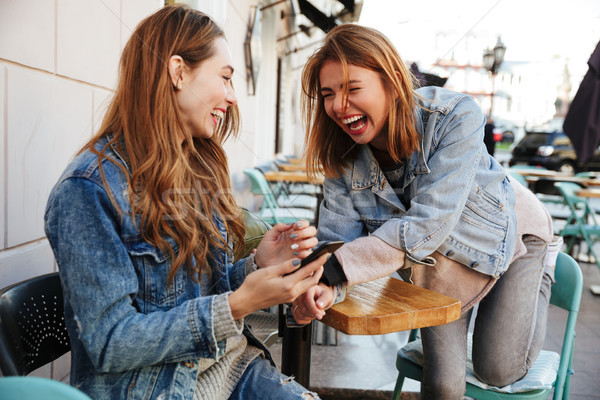 Two young beautiful woman friends in casual stylish wear laughin Stock photo © deandrobot