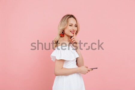 Image of Sly pensive blonde woman looking at the camera Stock photo © deandrobot