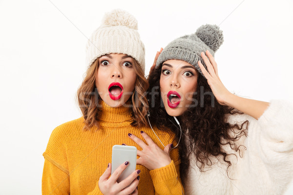 Close up image of Shocked girls in sweaters and hats Stock photo © deandrobot