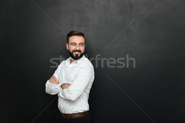 Portrait of cheerful good-looking man standing with arms folded, Stock photo © deandrobot