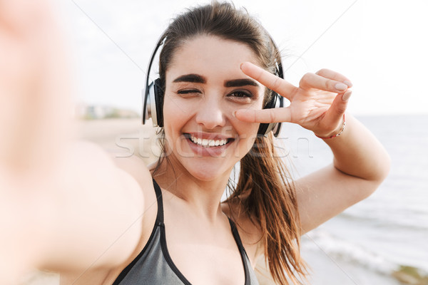 Szczęśliwy młodych sportsmenka słuchawki ręce Zdjęcia stock © deandrobot