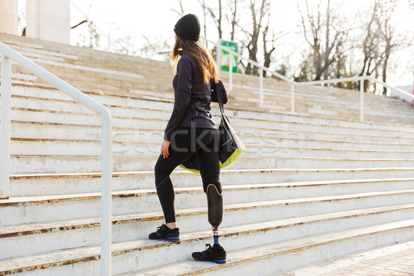 Photo from back of young athletic disabled girl with prosthetic  Stock photo © deandrobot