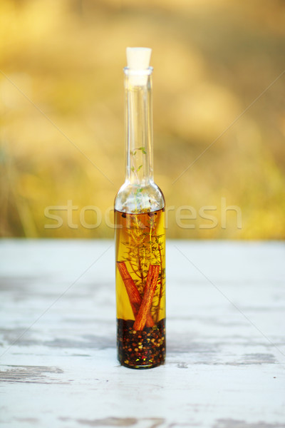 Bottle of olive oil on wooden vintage table with nature background Stock photo © deandrobot