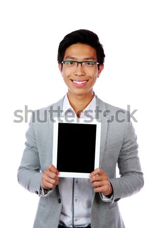 Smiling asian man showing tablet computer screen over white background Stock photo © deandrobot