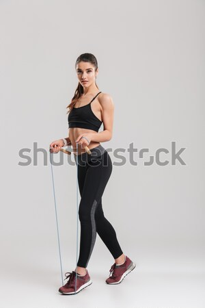 Side view portrait of a young woman working out at gym in bodysuit Stock photo © deandrobot