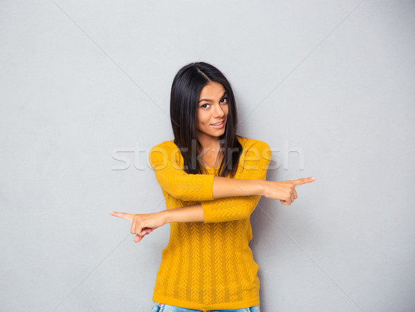Woman showing fingers in different directions  Stock photo © deandrobot