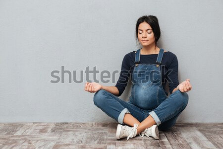 Mujer bonita meditando piso retrato casual gris Foto stock © deandrobot