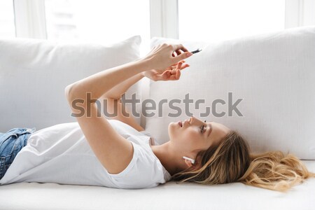 Woman lying on the bed and making selfie photo Stock photo © deandrobot