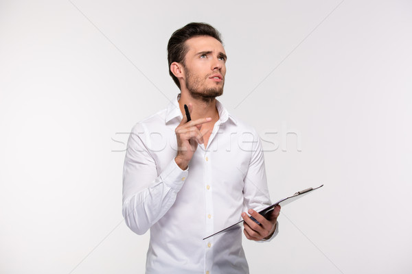 Pensive businessman holding clipboard Stock photo © deandrobot