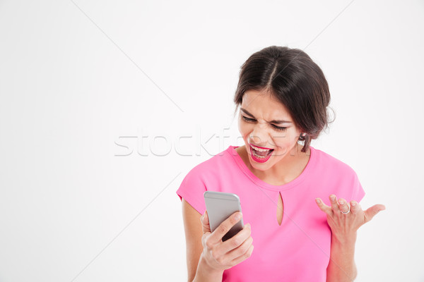 öfkeli deli genç kadın cep telefonu beyaz Stok fotoğraf © deandrobot