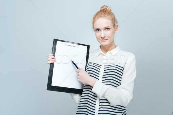 Stock photo: Young woman showing blank clipboard