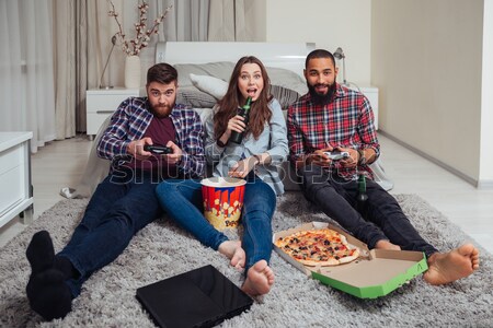 Two men playing computer games and sad offended woman sitting  Stock photo © deandrobot