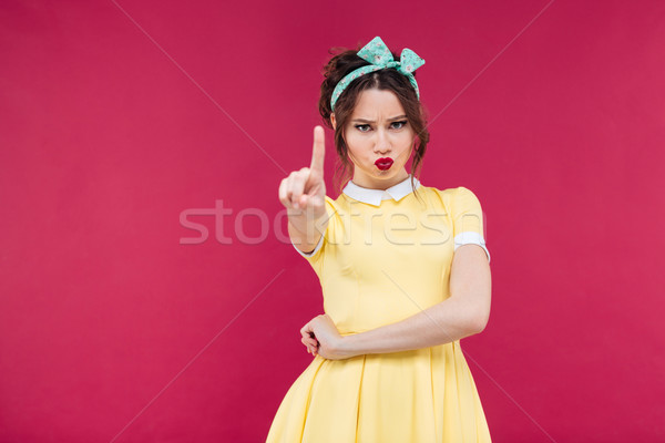 Komoly fiatal nő citromsárga ruha mutat figyelmeztető jel Stock fotó © deandrobot