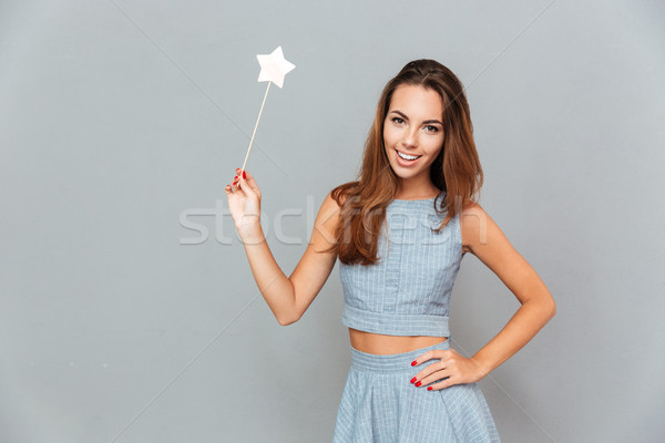 Stock photo: Cheerful beautiful young woman holding magic wand