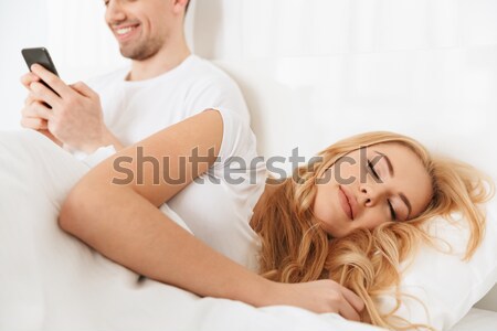 Cheerful woman lying and relaxing on bed in the morning Stock photo © deandrobot