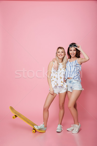 Dos feliz las mujeres jóvenes skateboard pie sonriendo Foto stock © deandrobot