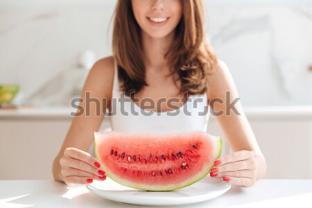 Smiling woman sitting at the kitchen table Stock photo © deandrobot