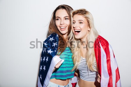 Happy female friends pointing at shirt with phrase and smiling isolated Stock photo © deandrobot