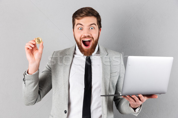 Portrait of an excited businessman showing bitcoin Stock photo © deandrobot