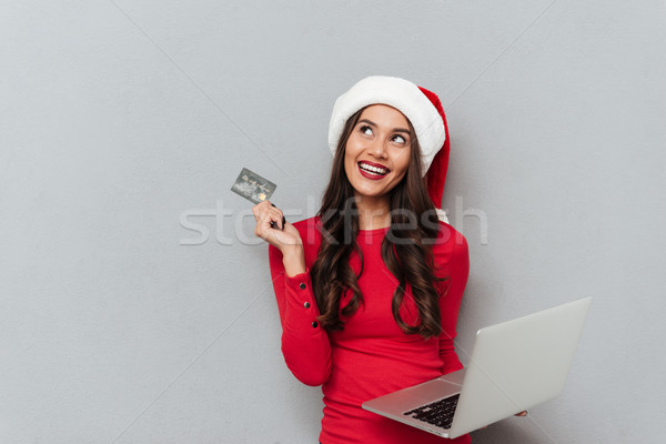 Charming brunette woman in Santa's hat and red blouse holding cr Stock photo © deandrobot