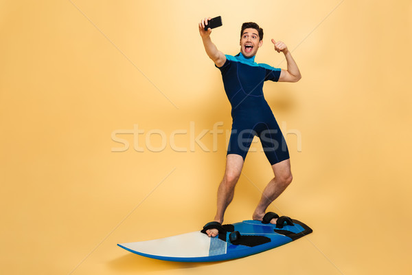 Full length portrait of a joyful young man Stock photo © deandrobot