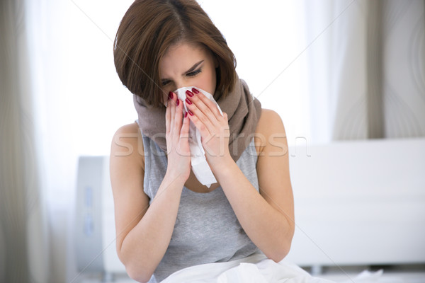 Sick Woman. flu. woman caught cold. sneezing into tissue Stock photo © deandrobot