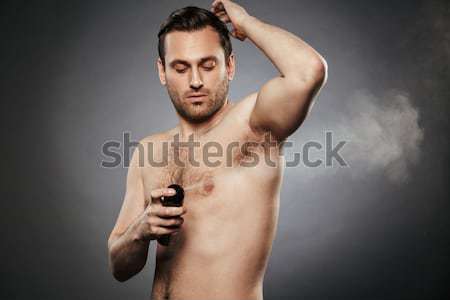 Man removing eyebrow hairs with tweezing Stock photo © deandrobot