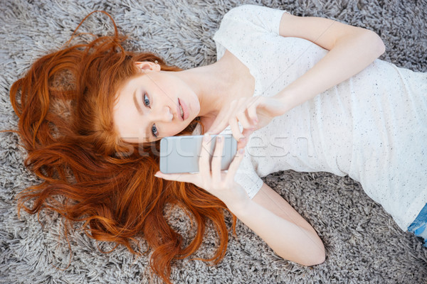 女子 地毯 智能手機 家 商業照片 © deandrobot