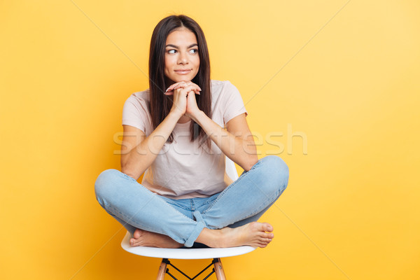 Stock photo: Happy woman sitting on the chair and looking away