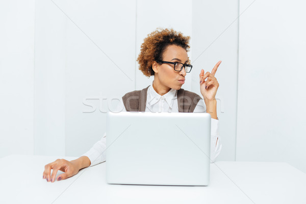 Inspired african american businesswoman pointing up and having an idea  Stock photo © deandrobot