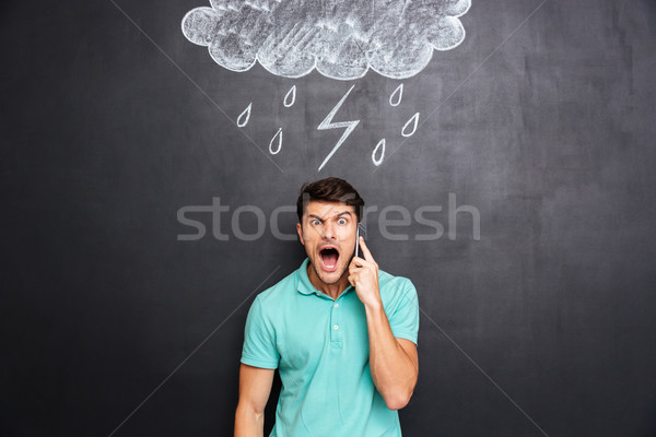 Man shouting on cell phone standing with black board Stock photo © deandrobot