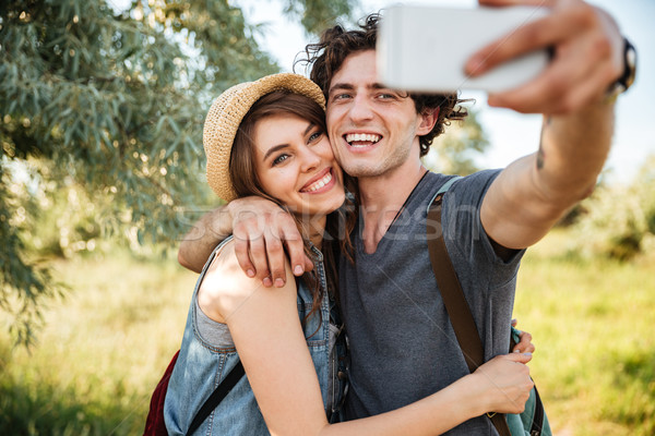 Couple with backpacks hiking in the forest and making selfie Stock photo © deandrobot