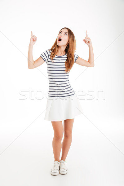 Casual inspired young woman pointing two fingers up Stock photo © deandrobot