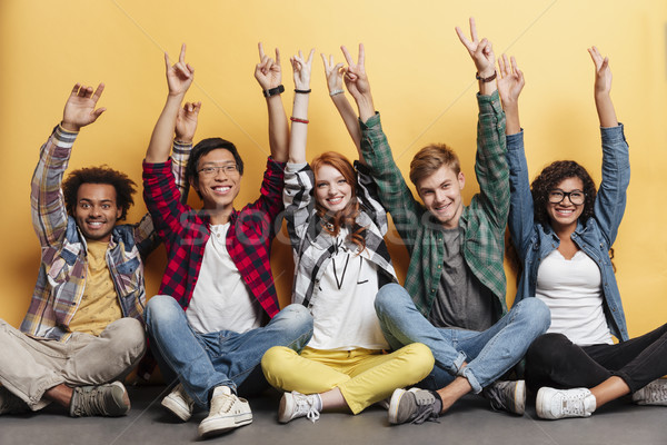 People celebrating success and showing peace sign with raised hands Stock photo © deandrobot
