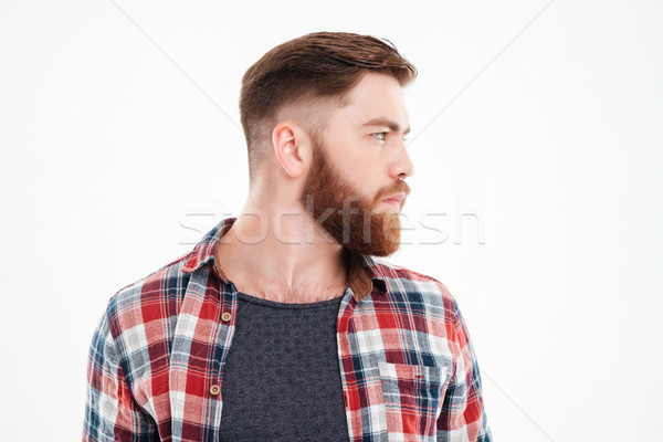 Serious bearded man in plaid shirt looking away Stock photo © deandrobot