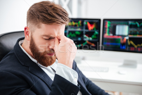 Stock photo: Tired bearded young businessman sitting and having headache