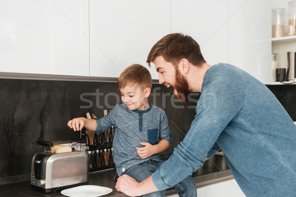 Handsome father cooking at kitchen with his little cute son Stock photo © deandrobot