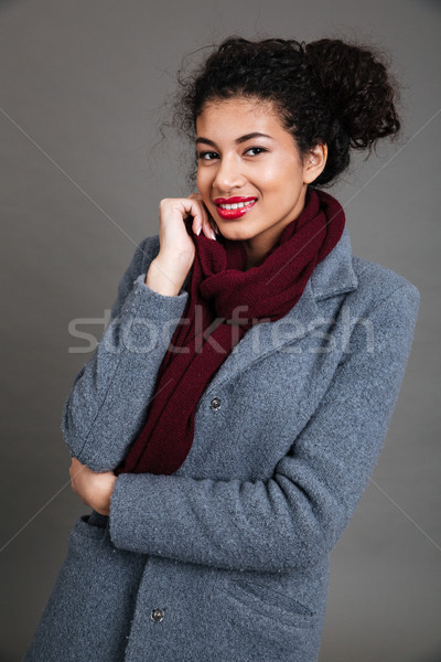 Happy pretty african american young woman in coat and scarf Stock photo © deandrobot