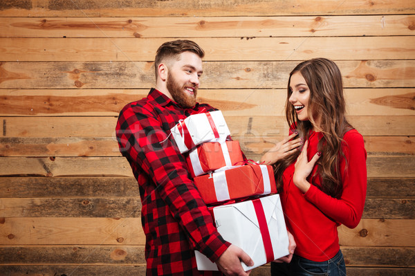 Happy joyful couple celebrating new year with heap of presents Stock photo © deandrobot