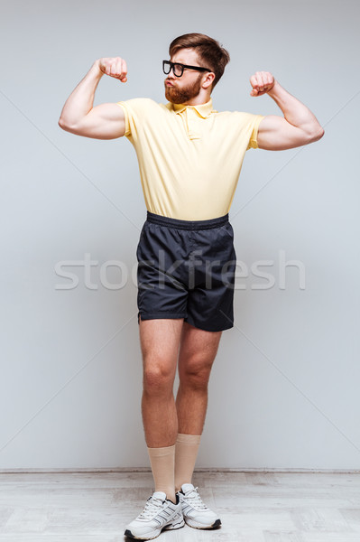 Vertical image of Male nerd showing his biceps Stock photo © deandrobot